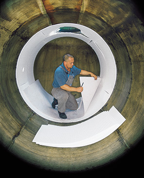 Monteur kleidet Tankinnenwand von Gebrauchttank mit Vlies aus als Vorbereitung f&uuml;r Innenh&uuml;lleneinbau