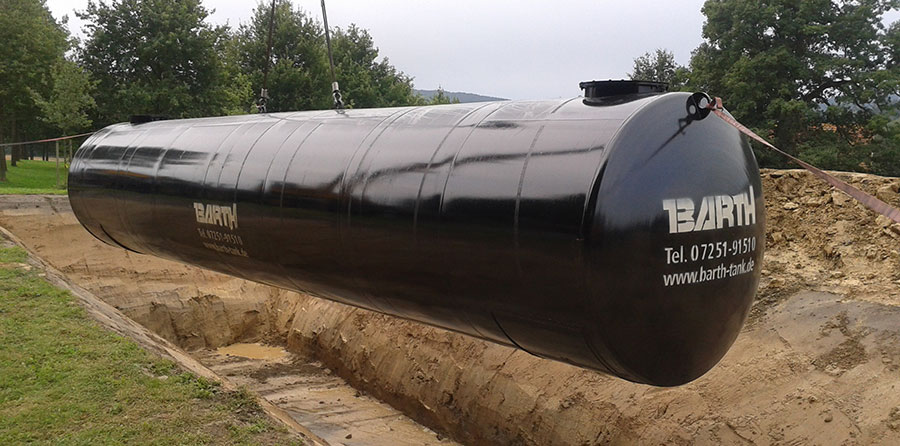 Schwarz beschichteter, unterirdischer L&ouml;schwassertank w&auml;hrend des Erdeinbaus, am Kran h&auml;ngend, Wassertank von Firma Tank und Apparate Barth GmbH